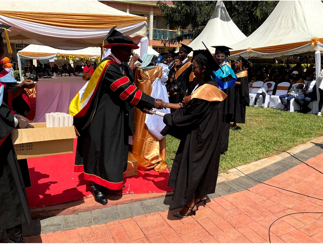 A graduand receiving her certificate from the guest of honour