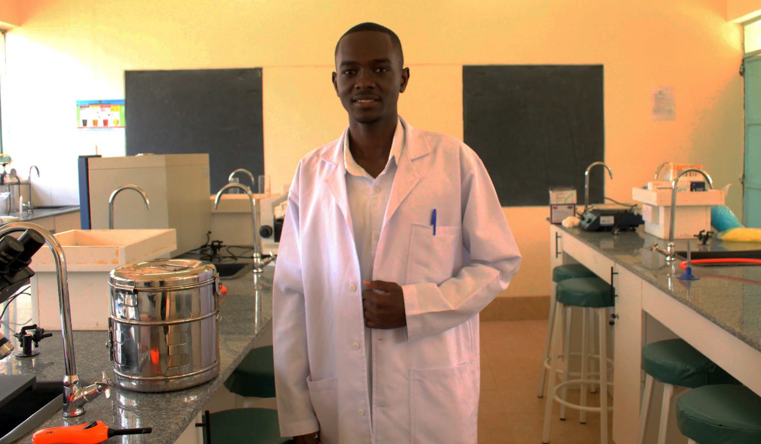 A student in a lab coat inside the college teaching laboratory